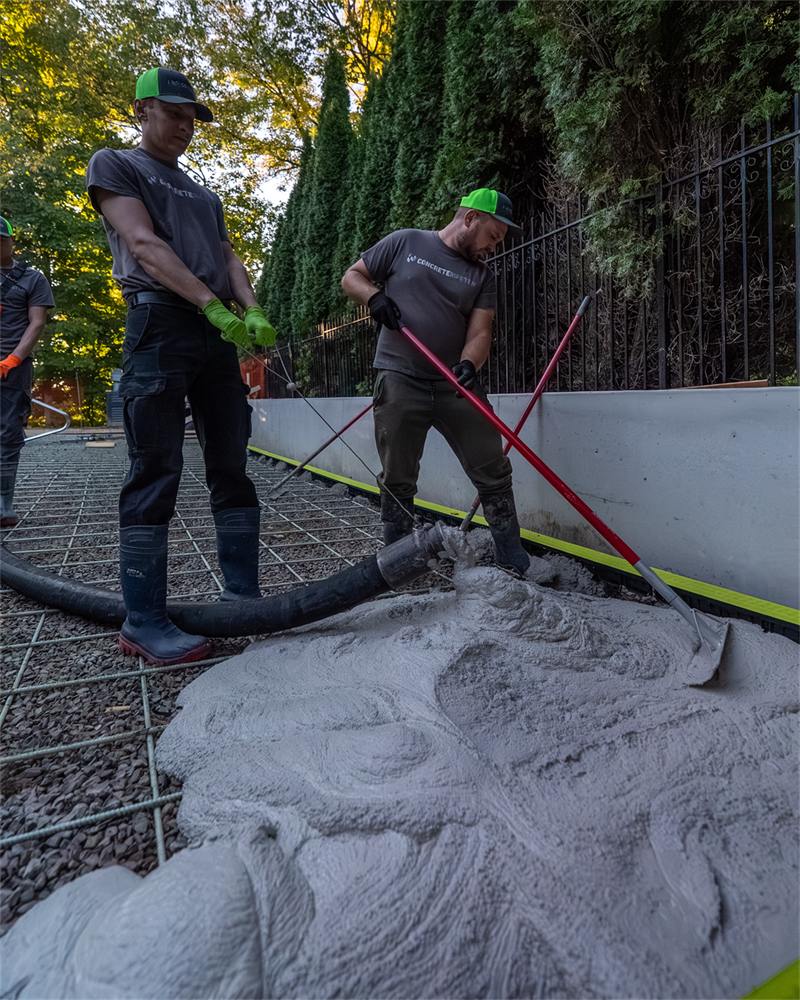 Crew preparing a compacted granular base ahead of a retaining wall installation