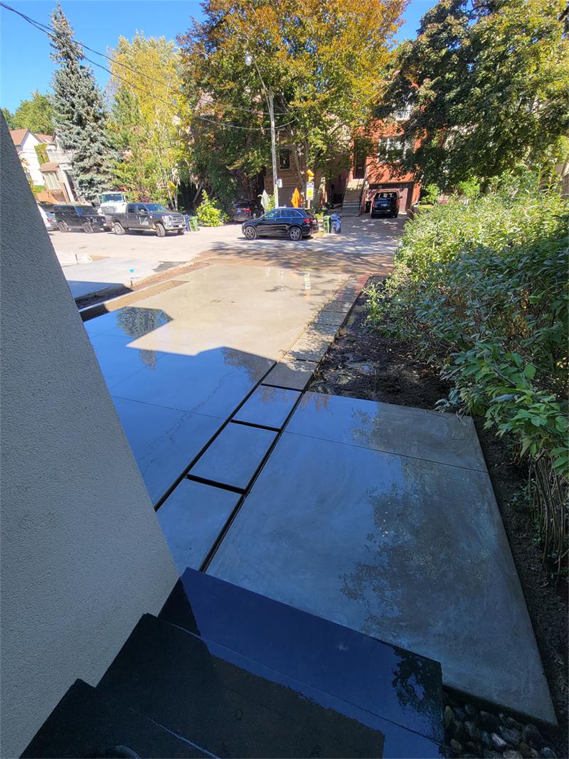 Smooth concrete driveway apron and steps, wet after being washed down