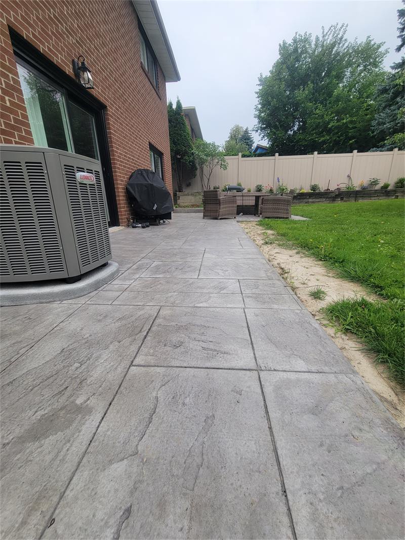 Stamped concrete side walkway running past an air conditioning unit